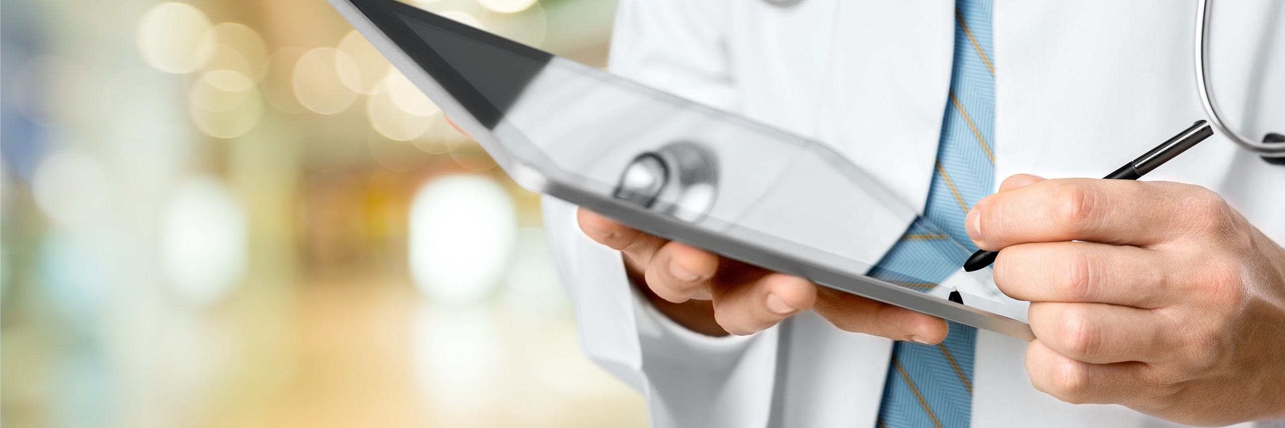 Health care provider holding a tablet and stylus pen.