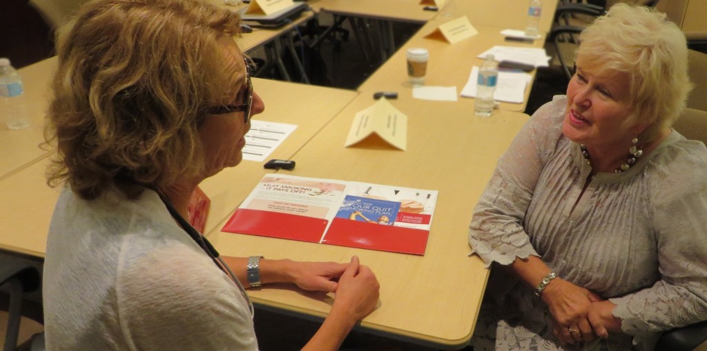 Healthcare provider engaging in conversation with an elderly woman.